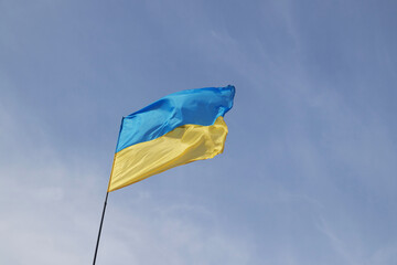 Ukrainian yellow and blue flag develops in the wind against the sky