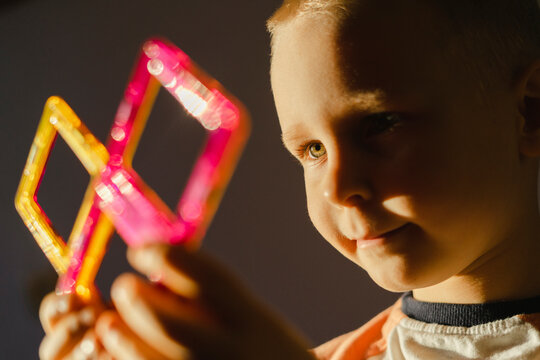 Smiling boy playing with magnetic tiles