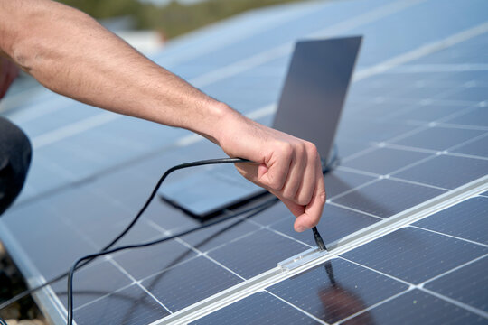 Engineer Plugging In Power Supply Cable Charger Of Laptop To Solar Panels