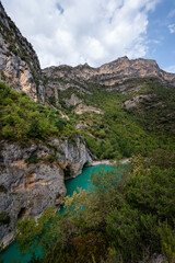 Deep turquoise river at the bottom of a vertical canyon