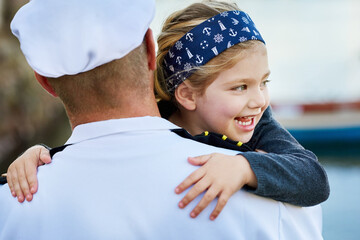 Excited to have her daddy back home. Rearview shot of a father in a navy uniform hugging his happy...