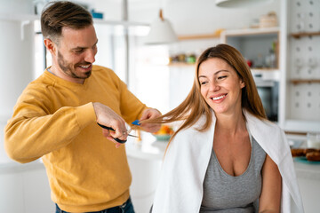 Couple having hair cut at home during quarantine coronavirus pandemic, online hairdressing on tablet