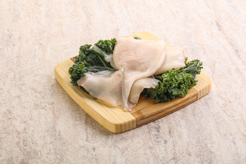 Raw squid over wooden board