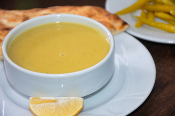 Traditional Turkish, Asian, red lentil soup served with a slice of lemon, pickled pepper and pita bread