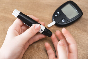 Child Hands Using Lancet on Finger to Check Blood Sugar Level by Glucometer.