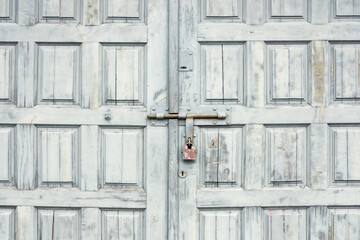 Wooden door background. Garage door texture. Abandoned locked gate. Metal padlock with peeling paint.