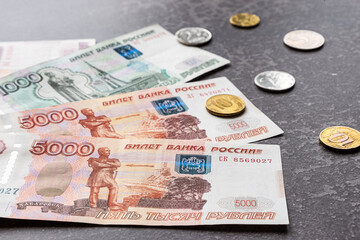 Russian rubles as banknotes and coins on a dark background. Financial crisis, ruble devaluation...