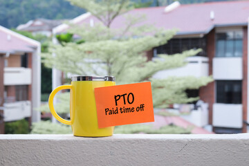 PTO or paid time off concept. A PTO notes sticking on the yellow mug 