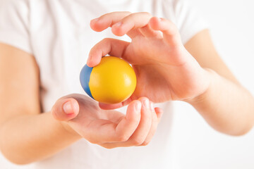 Little girl holding easter eggs on blue and yellow background.