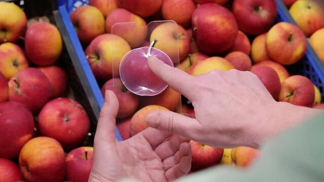 Woman uses eco tester when choosing fruits and vegetables in supermarket before buying. Futuristic non-contact nitrate meter in human hand scanning apples in market. Screen shows  good result.