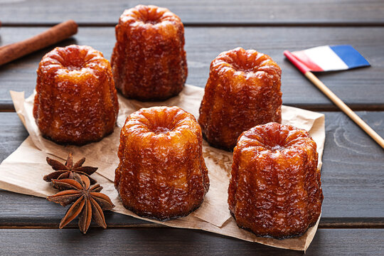 Local French dessert canele on a dark wooden background