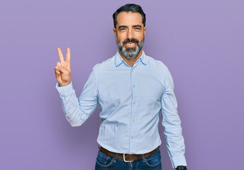 Middle aged man with beard wearing business shirt smiling looking to the camera showing fingers...