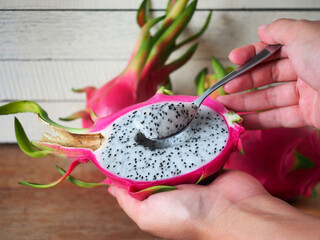 Dragon fruit in metal spoon and woman hand
