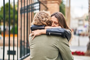 Man and woman couple smiling confident hugging each other at street