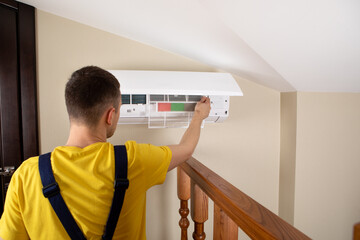 Male technician cleaning air conditioner indoors