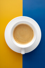 Black coffee in a cup on Ukraine flag blue and yellow background