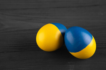 easter egg with the flag of Ukraine on a wooden background.