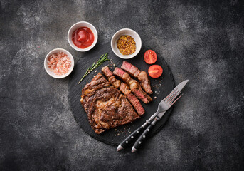 Medium rare Ribeye steak or beef steak on the black tray with tomatoes. Top view, flat lay. - 496779559