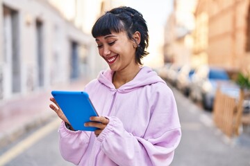 Young woman smiling confident using touchpad at street