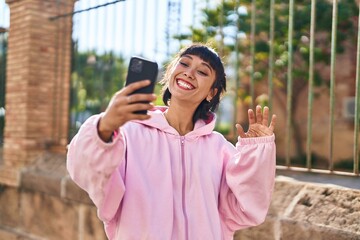 Fototapeta premium Young woman smiling confident having video call at street