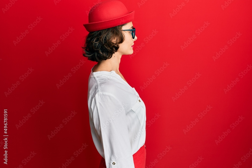 Poster Young brunette woman wearing stewardess style and glasses looking to side, relax profile pose with natural face with confident smile.