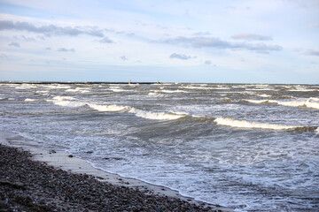 Fototapeta na wymiar Baltic sea shoreside view with waves and cloudy weather.