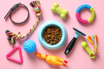 Different pet accessories and bowl of dry feed on pastel pink background. Flat lay, top view.