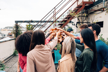 group of young people toasting with beer - party of young generation z people