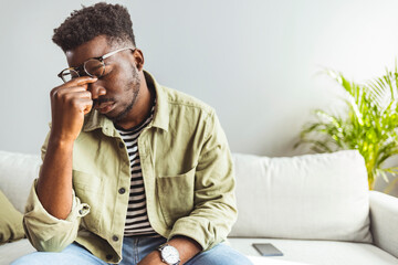 Upset stressed young african american man coping with strong headache concept, upset exhausted...