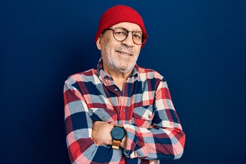 Handsome mature man wearing hipster look with wool cap relaxed with serious expression on face. simple and natural looking at the camera.