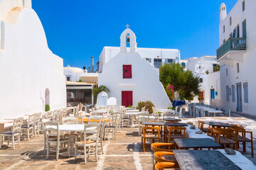 Famous old town narrow street with cafe and chapel. Mykonos island, Greece