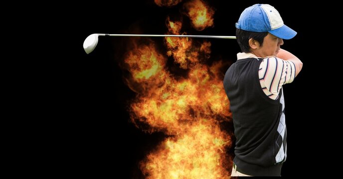 Asian male golf player swinging golf club against fire flame effect on black background