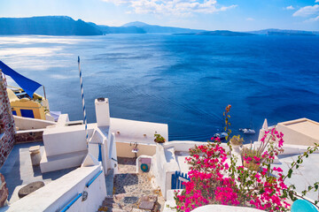 Beautiful sea view with bougainvillea flowers in Oia, Santorini, Greece. Iconic image of vacation in Greece