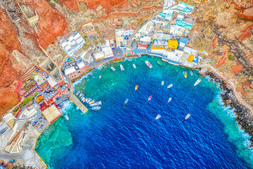 Aerial drone view of Old port Amoudi bay in Oia village with fishing boats. Santorini island in Aegean sea, Greece