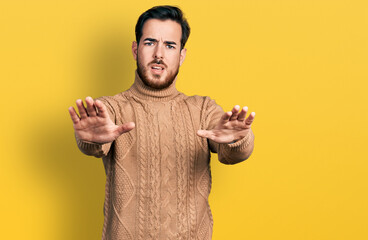 Young hispanic man wearing casual clothes doing stop gesture with hands palms, angry and frustration expression