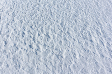 Relief snow surface of a frozen river in the winter