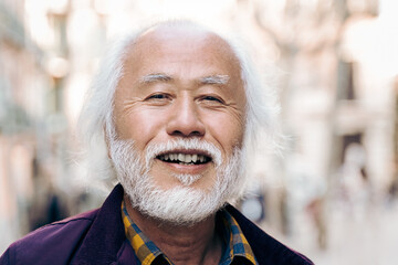 Senior Asian man smiling at camera outdoor - Focus on male eyes