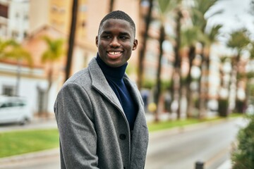 Fototapeta premium Young african american man smiling happy standing at the city