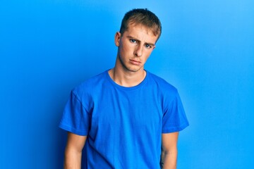 Young caucasian man wearing casual blue t shirt depressed and worry for distress, crying angry and afraid. sad expression.