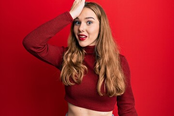 Young blonde woman wearing turtleneck sweater surprised with hand on head for mistake, remember error. forgot, bad memory concept.