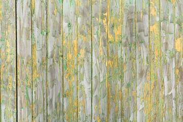 An old wooden fence, with cracked gray and yellow paint as a background