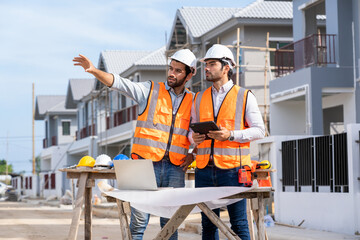 Architect and engineer discussing planning for a building a new home at construction site,Architect...
