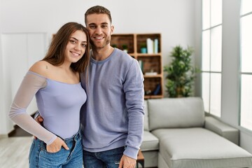 Young caucasian couple smiling happy standing at home.