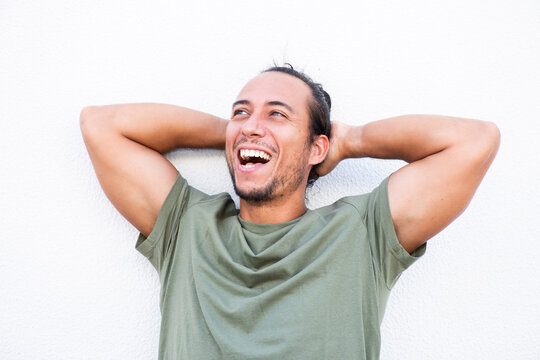 Man with hands behind head laughing