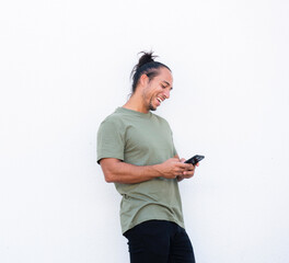 Cheerful man with pulled up hair bun using mobile phone over white background