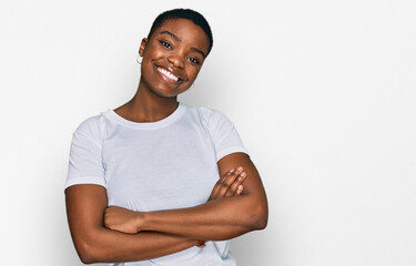 Young african american woman wearing casual white t shirt happy face smiling with crossed arms looking at the camera. positive person.