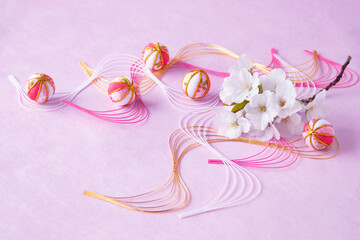 日本の正月イメージ　桜の花束と可愛い手毬と波型水引のデザイン（ピンクバック）