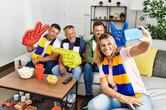 Group of middle age friends watching and supporting soccer match  make selfie by the smartphone at home.