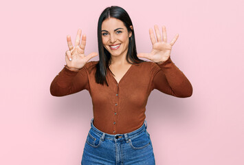 Obraz na płótnie Canvas Young hispanic woman wearing casual clothes showing and pointing up with fingers number nine while smiling confident and happy.