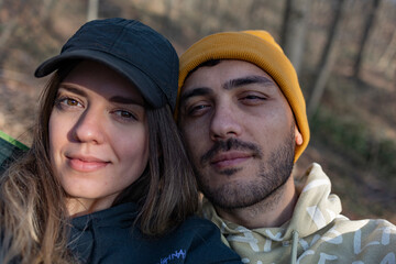 Close up photo of young couple in forest. Camping, nature and relationship concept. Selfie. 